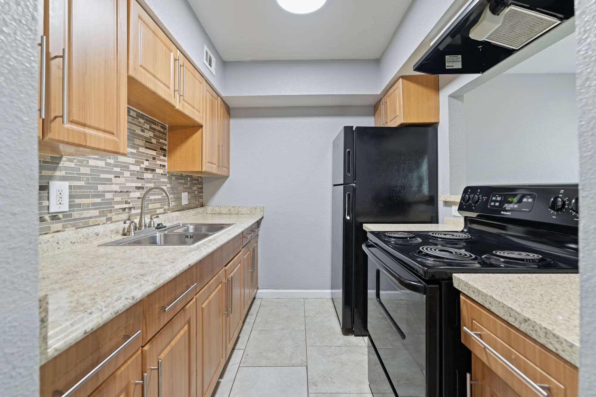 Full Waverly apartment kitchen with cabinetry and black appliances