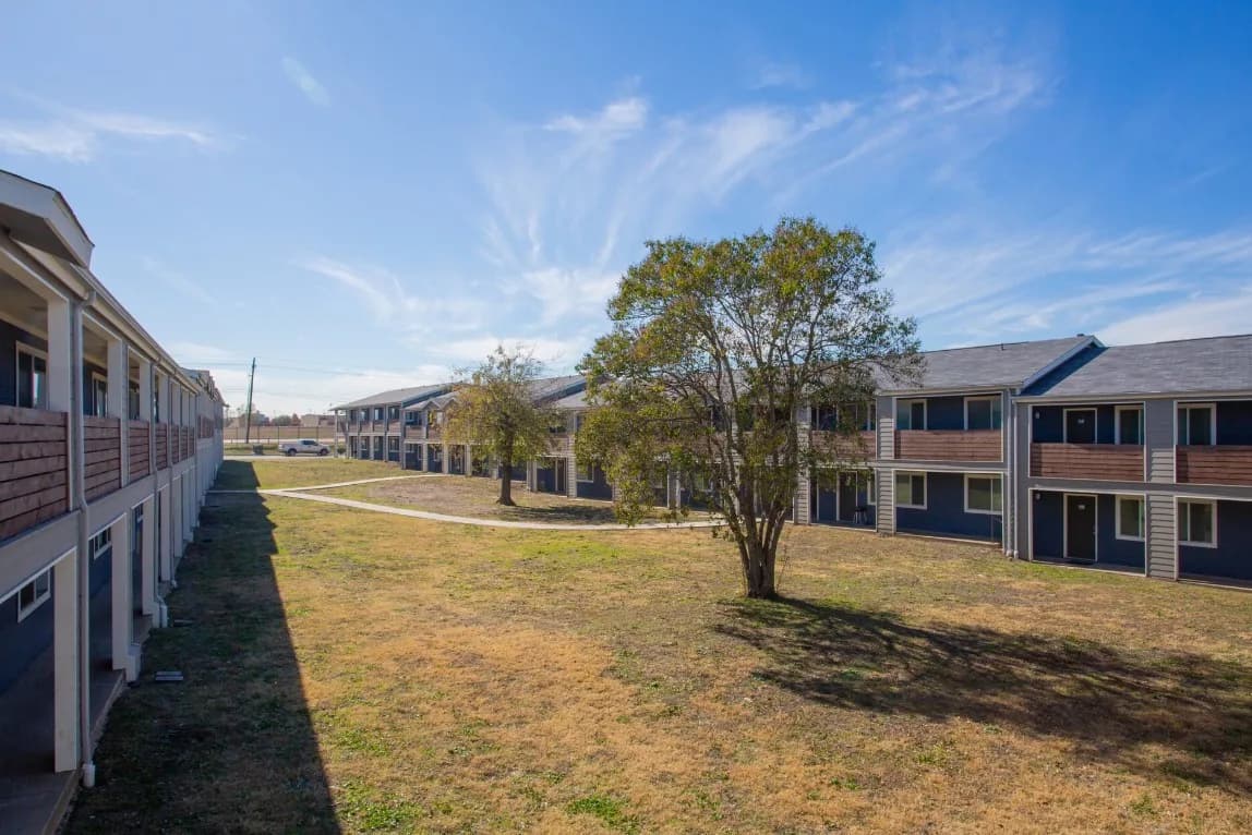 Open courtyard with grass, trees and walkways at Waverly Apartments